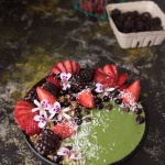 bowl with green smoothie and berries