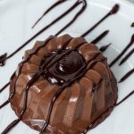 A plate with Chocolate Panna Cotta drizzled with chocolate sauce.